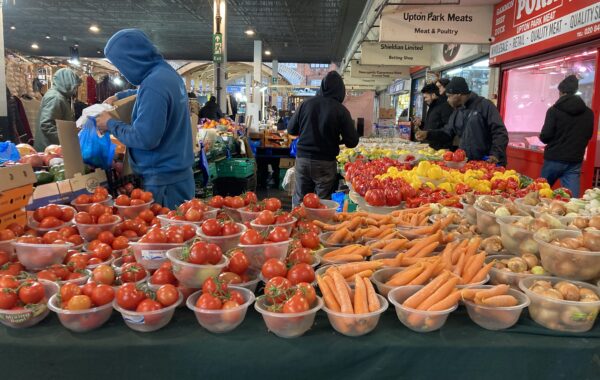 A market trader selling fruit and veg in Newham, London